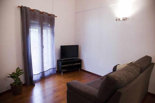 sala de estar con sofá y TV en Casa La Lourdes, en Ainet de Besan