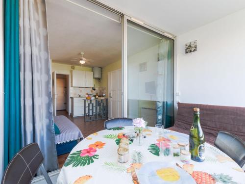 - une table avec une bouteille de vin et des fleurs dans l'établissement Studio Floralies I-6 by Interhome, au Grau-du-Roi