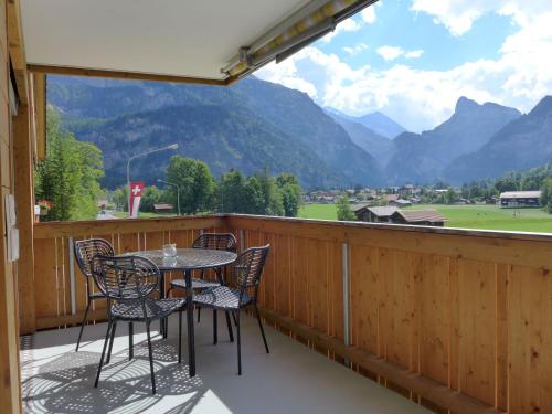 a balcony with a table and chairs and mountains at Apartment Lantau by Interhome in Kandersteg