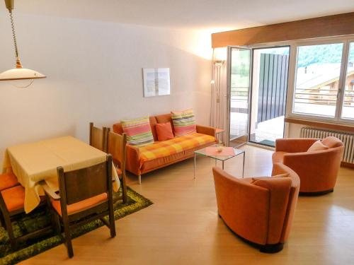 un soggiorno con divano, tavolo e sedie di Apartment Ringstrasse - Utoring-24 by Interhome a Leukerbad