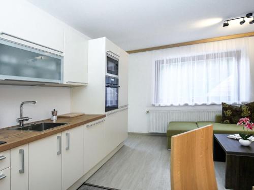 kuchnia i salon z kanapą i stołem w obiekcie Apartment Schwarzwald by Interhome w mieście Radenthein