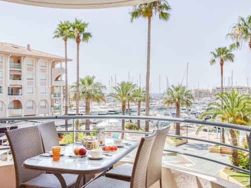 d'une table et de chaises sur un balcon avec des palmiers. dans l'établissement Apartment Royal Marine-5 by Interhome, à Fréjus