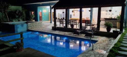 a swimming pool with blue lights in a house at SÍTIO MARAVILHOSO EM MAIRIPORÃ opção de 1 quarto para 8 pessoas ou 4 quartos acima de 9 pessoas in Mairiporã