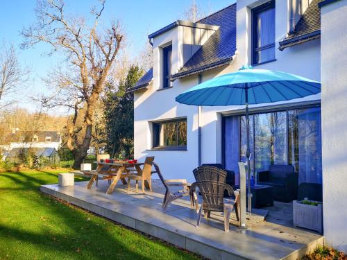 a patio with a table and chairs and an umbrella at Holiday Home L'allée Couverte by Interhome in La Trinité-sur-Mer