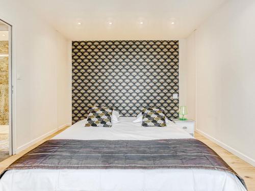 een slaapkamer met een groot bed en een grote muur bij Holiday Home L'allée Couverte by Interhome in La Trinité-sur-Mer