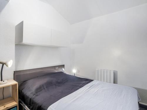 une chambre avec un lit et un mur blanc dans l'établissement Apartment La Gaillarde-15 by Interhome, aux Issambres