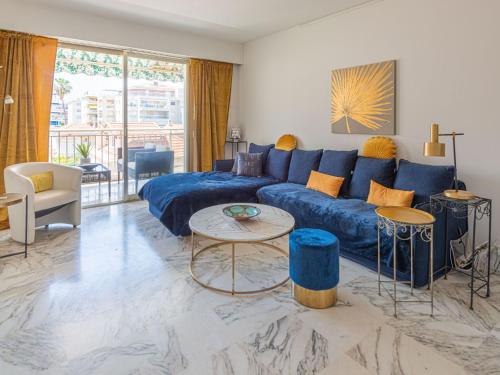 - un salon avec un canapé bleu et une table dans l'établissement Apartment Presqu'Ile by Interhome, à Cannes