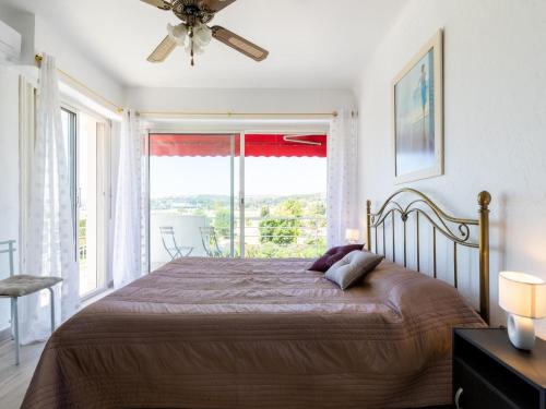 une chambre avec un lit et une grande fenêtre dans l'établissement Apartment L'Auteuil by Interhome, à Cagnes-sur-Mer