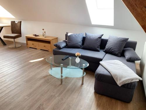 a living room with a blue couch and a glass table at Apartment Baltrum by Interhome in Westerholt