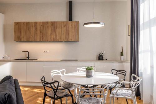 a kitchen with a white table and chairs in a room at Apartmány Marienhof in Znojmo