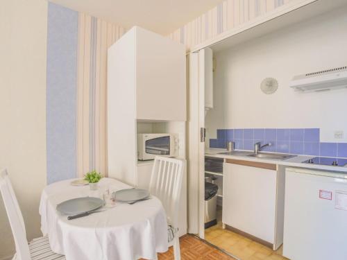 une petite cuisine avec une table blanche et un évier dans l'établissement Studio Le Saint François by Interhome, à Saint-Aygulf