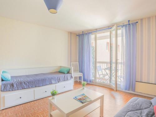 una sala de estar con una cama y una mesa en Studio Le Saint François by Interhome, en Saint-Aygulf