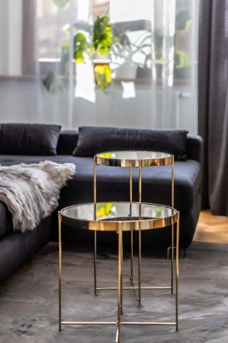 a gold and glass coffee table in front of a couch at Apartmány Marienhof in Znojmo