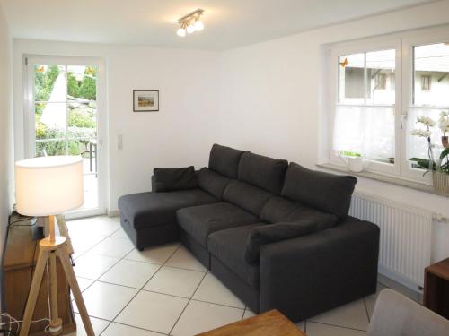 a living room with a black couch and windows at Apartment Mittelberghof by Interhome in Hofstetten