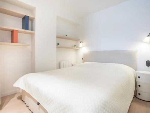 - une chambre avec un lit blanc et des étagères dans l'établissement Apartment Winston by Interhome, à Dinard