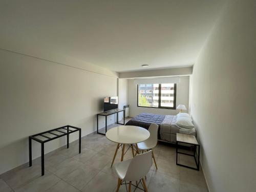 een slaapkamer met een bed en een tafel en stoelen bij Departamento Céntrico Bariloche in Bariloche
