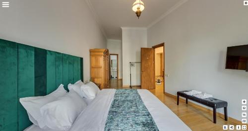 1 dormitorio con 1 cama grande y cabecero verde en Octava Boutique Hotel en Tiflis