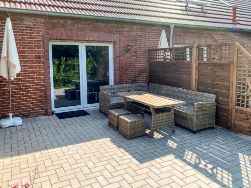a patio with a table and chairs and a brick building at Apartment Wangerooge by Interhome in Westerholt
