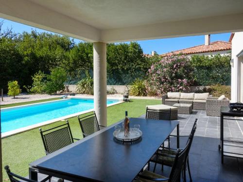 um pátio com uma mesa e cadeiras e uma piscina em Villa Bastide de la Mer by Interhome em Bormes-les-Mimosas