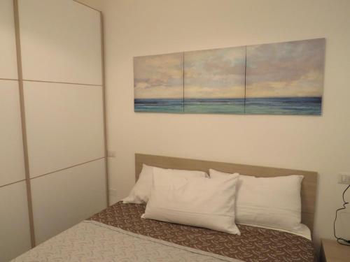 una camera da letto con un letto e due dipinti alle pareti di APPARTAMENTO PETRARCA a Cervia