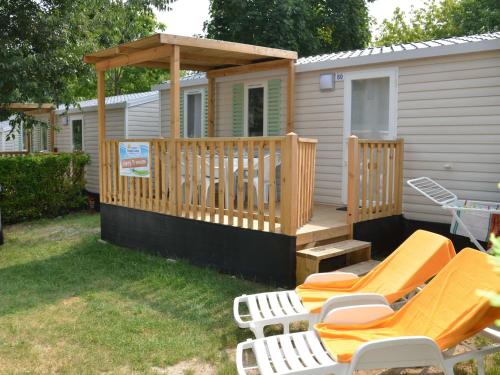 a cabin with a deck with chairs and a gazebo at Holiday Home Happy Premium by Interhome in Torre Santa Sabina