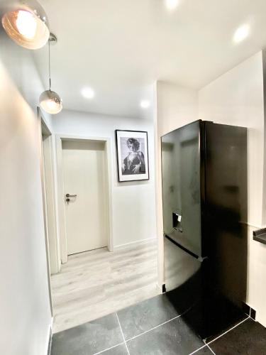 a black refrigerator in a room with a hallway at Living Solution 24 Karlsruhe in Karlsruhe