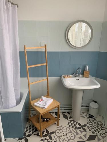 Un baño con un lavabo y una escalera al lado de un espejo. en Hôtel L'Estran, en Trouville-sur-Mer