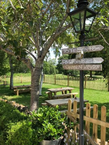 a street sign in front of a park with benches at The Bridge House in Bridport