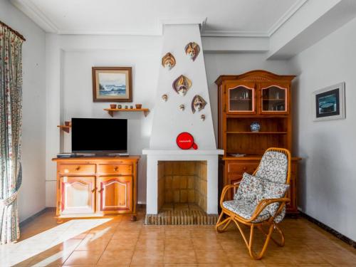salon z telewizorem i krzesłem w obiekcie Apartment Rinconada Real-3 by Interhome w mieście Benidorm