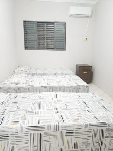 a bedroom with two beds and a window at Pousada São Francisco in Cuiabá