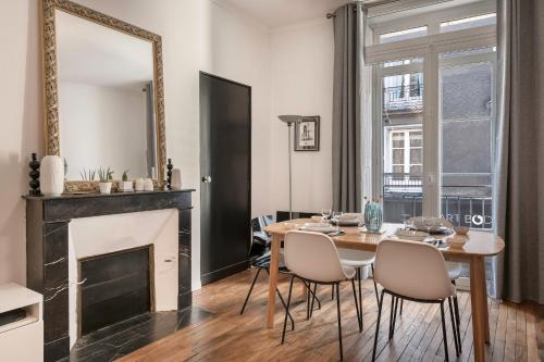 une salle à manger avec une table, des chaises et un miroir dans l'établissement Chaleureux appartement proche de la Place Graslin, à Nantes