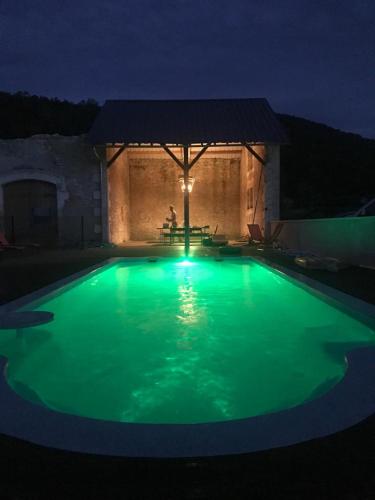 - une piscine verdoyante avec un kiosque la nuit dans l'établissement La Cour de La Fleunie 1, à La Machome