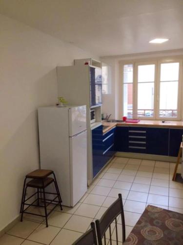 DieulouardにあるAppartement charmant à Dieulouard, 75 m² avec Parkingのキッチン(白い冷蔵庫、青いキャビネット付)
