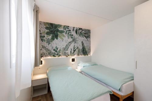 ein Schlafzimmer mit 2 Betten und einem Wandgemälde in der Unterkunft Agriturismo Agricamping GARDA NATURA in Costermano sul Garda