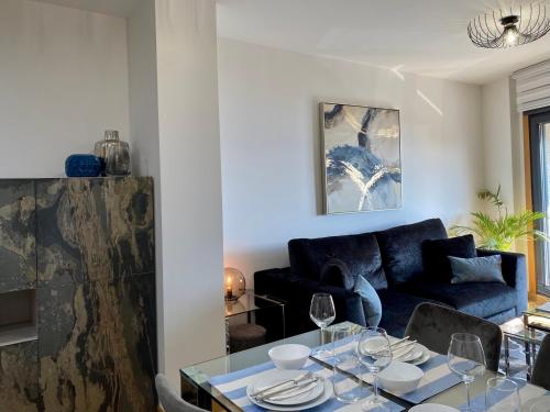 sala de estar con sofá azul y mesa de cristal en AMIVERA-MAR, vistas a la Ría de Vigo, Cangas, en Cangas de Morrazo