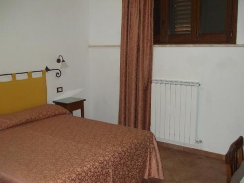 a bedroom with a bed and a window and a curtain at Camere Ramaccia in Assisi