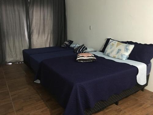 1 dormitorio con 2 camas y sábanas azules en Casa de aluguel Gregório, en Imbituba