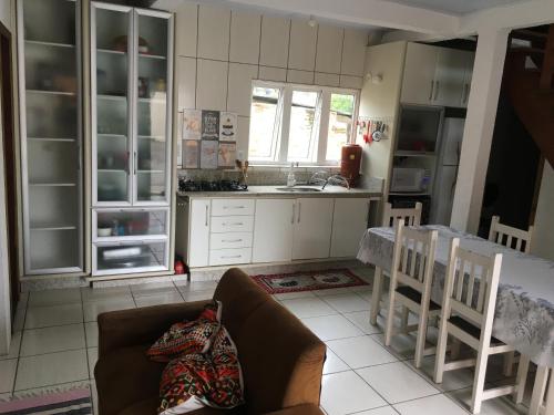 a kitchen with a couch and a table in a room at Casa de aluguel Gregório in Imbituba