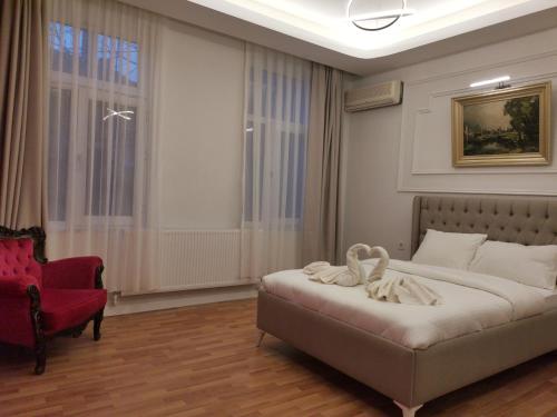 a bedroom with a bed and a red chair at St Moscow Suites Taksim in Istanbul