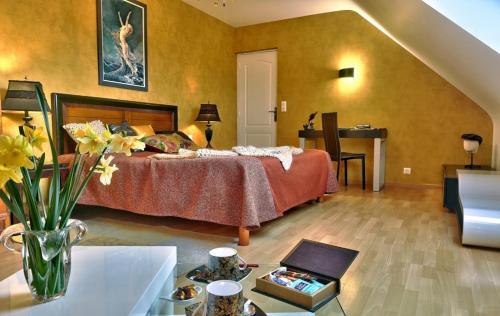 a bedroom with a bed and a table with flowers at Lanévry, Ville d'Ys in Kerlaz