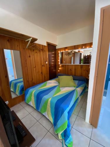 une chambre avec un lit avec une couette colorée dans l'établissement Studio Grotte des fées, à Hyères