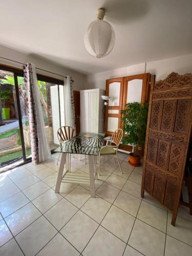 une salle à manger avec une table et des chaises en verre dans l'établissement Studio Grotte des fées, à Hyères