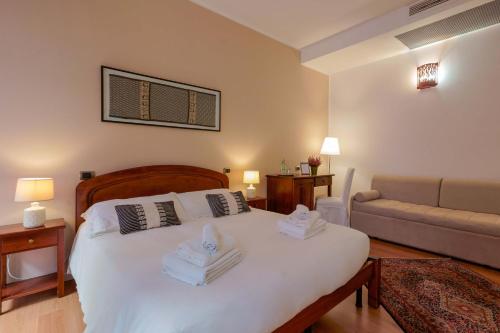 a bedroom with a large white bed with towels on it at Sa Domu Cheta in Cagliari