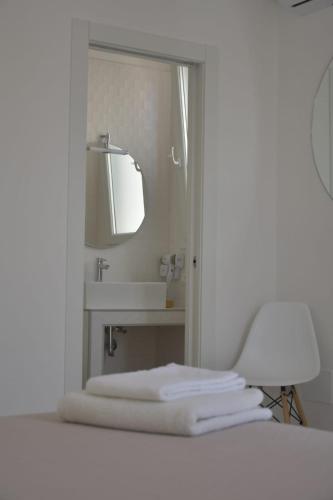a bathroom with a mirror and a sink with towels at Mimi Leuca B&b in Leuca