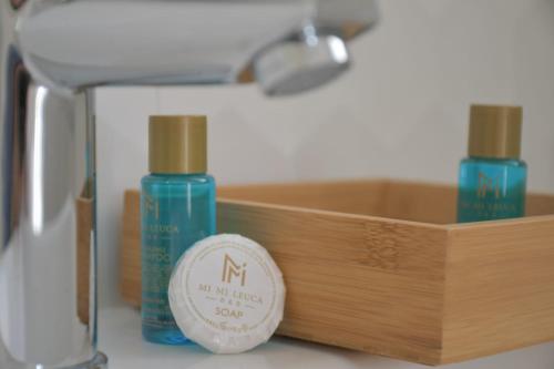 two bottles ofodorizers sitting next to a wooden box at Mimi Leuca B&b in Leuca