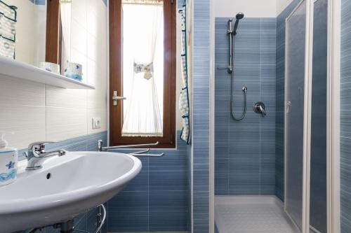 a bathroom with a sink and a shower at Casa Marcella in Costa Rei