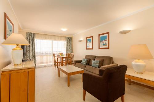 a living room with a couch and a table at Interpass Vau Hotel Apartamentos in Portimão