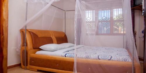 a bed with a mosquito net in a room at Dream Palace Hotel Mbale in Mbale