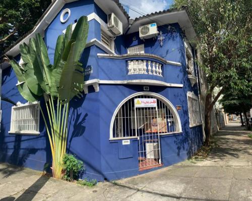 a blue house with a palm tree in front of it at Hostel Maktub in Sao Paulo