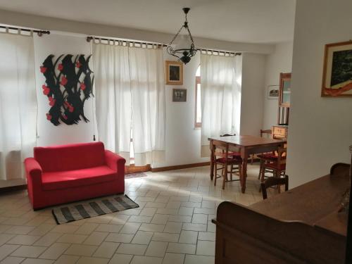 salon z czerwonym krzesłem i stołem w obiekcie Residenza Schinardi w mieście Oristano
